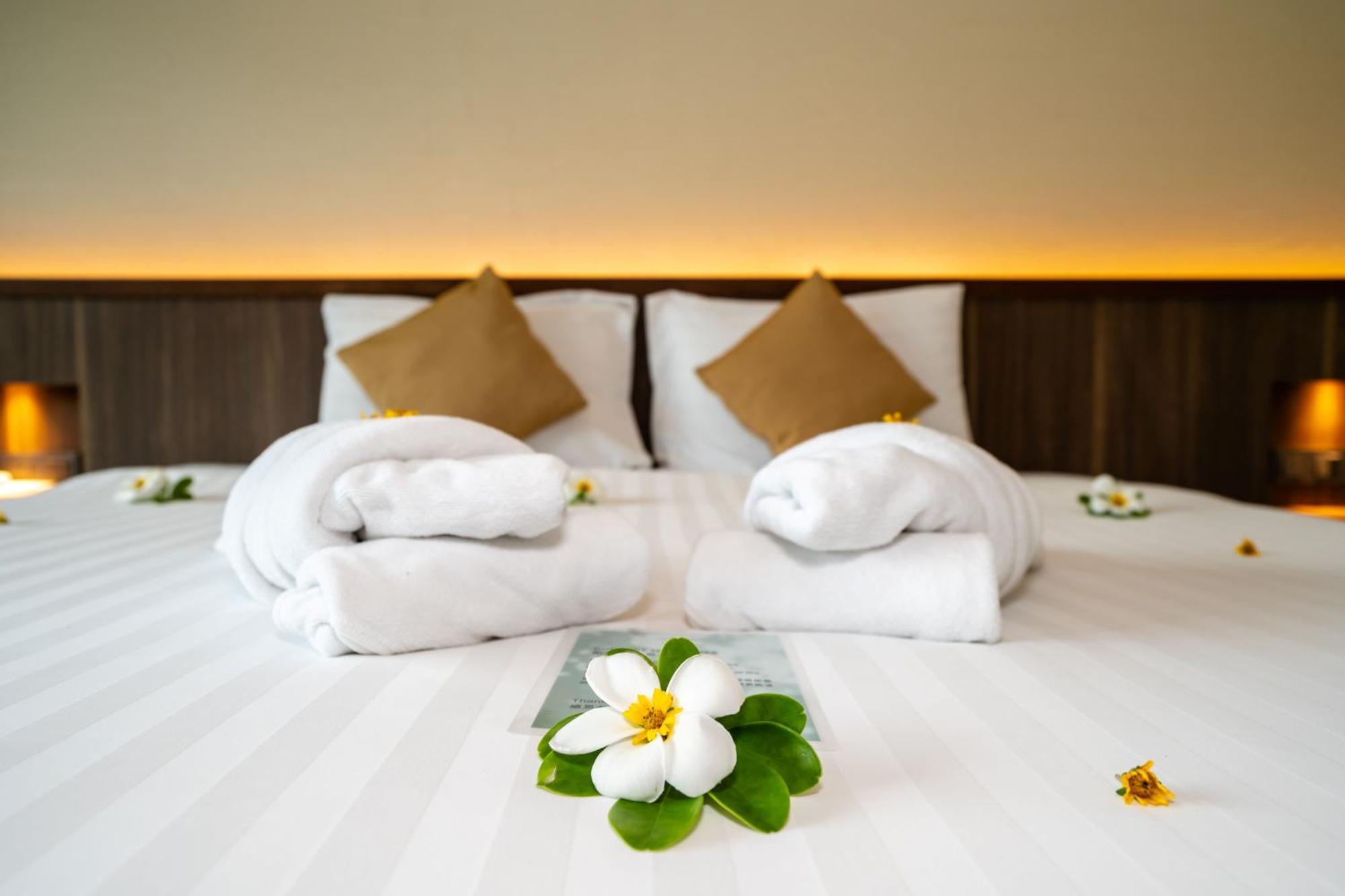 Le Resort And Villas Rawai Ngoại thất bức ảnh A bed with towels and flowers